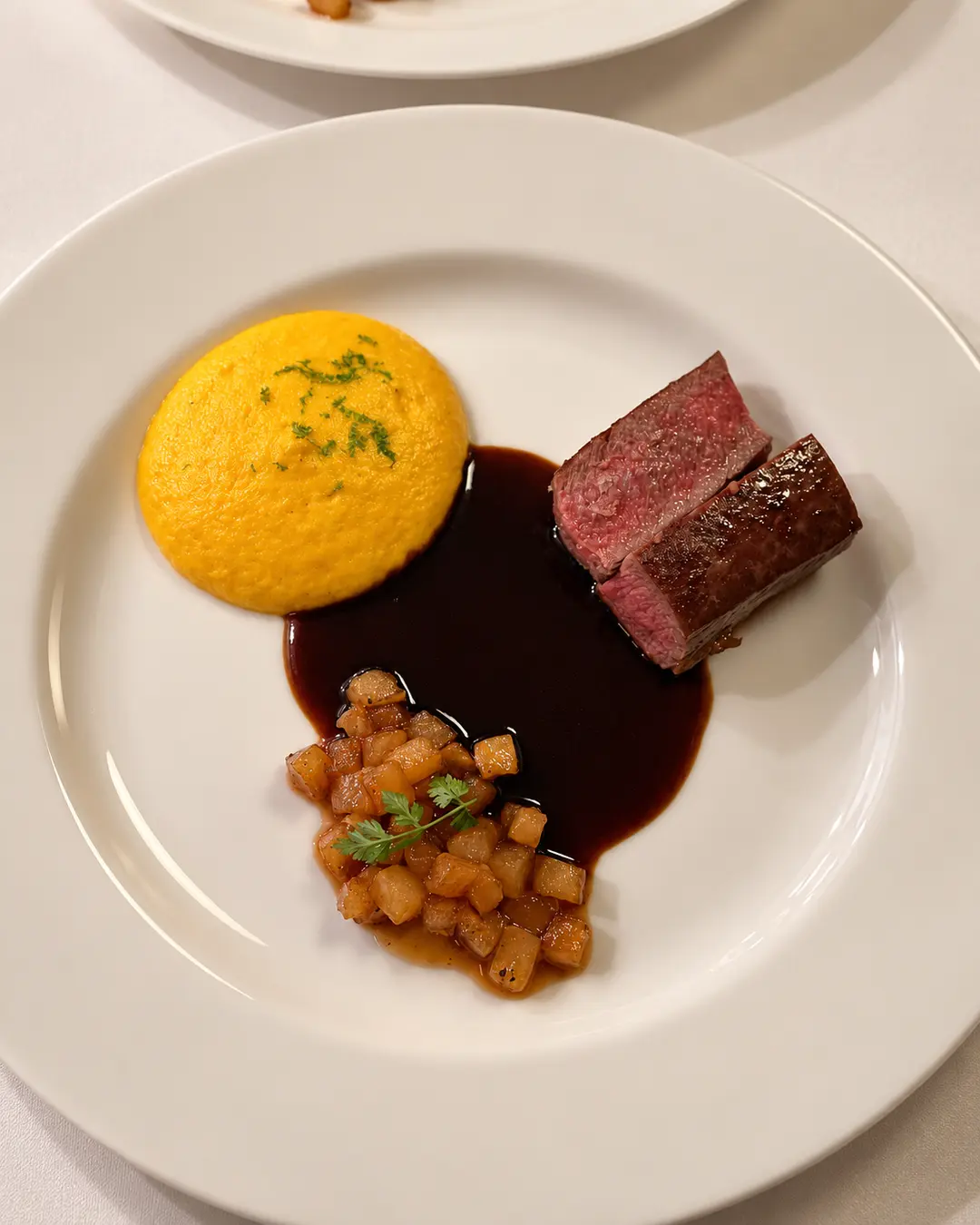 Rosa gebratenes Fleisch mit dunkler Jus und Püree